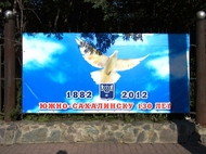 ハトが平和のシンボルとして描かれているユジノ・サハリンスク市開基１３０周年記念広告